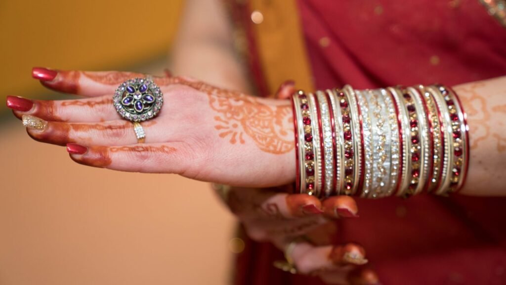 Menu Close-up of a hand with intricate henna and ornate bangles, ideal for wedding themes.