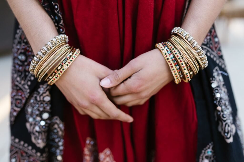 Menu Close-up of a woman's hands adorned with colorful traditional bangles, showcasing cultural attire.
