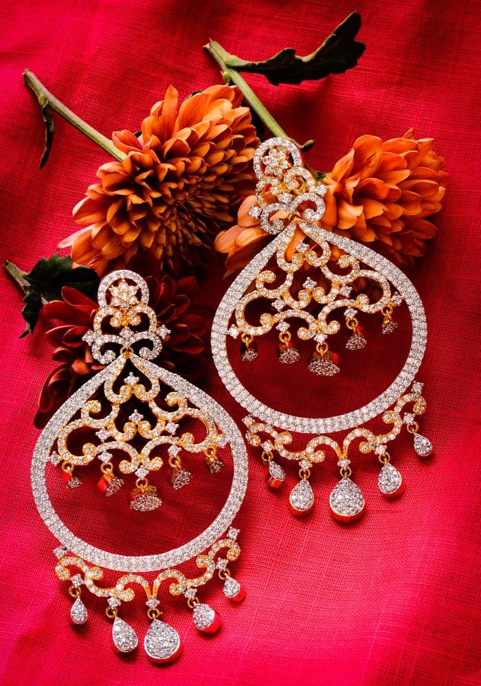 Menu Exquisite diamond earrings set against a vibrant red background paired with blooming dahlias.